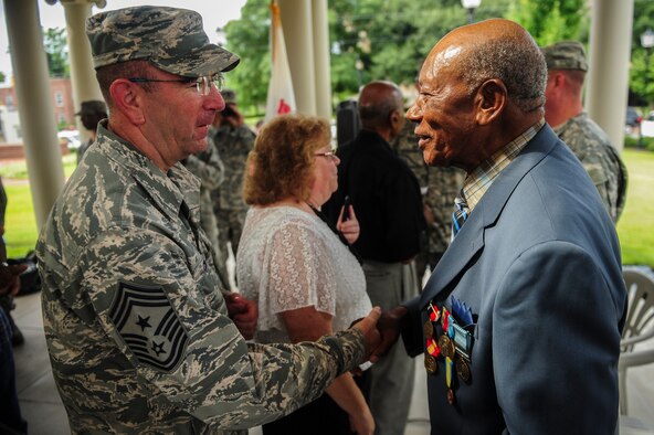 Chief Master Sgt. Jeffrey Craver, 4th Fighter Wing command chief, shakes hands with retired Staff. Sgt. Elbert Scott after a medal presentation ceremony, July 21, 2014, in downtown Goldsboro, North Carolina. Scott was presented six medals for his service during World War II and the Korean War. (U.S. Air Force photo/Airman 1st Class Brittain Crolley)