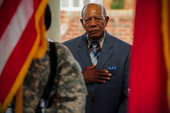 Retired Staff Sgt. Elbert Scott places his hand over his heart during the playing of the national anthem at a medal presentation ceremony in his honor, July 21, 2014, in downtown Goldsboro, North Carolina. Scott was presented six medals for his service during World War II and the Korean War. (U.S. Air Force photo/Airman 1st Class Brittain Crolley)