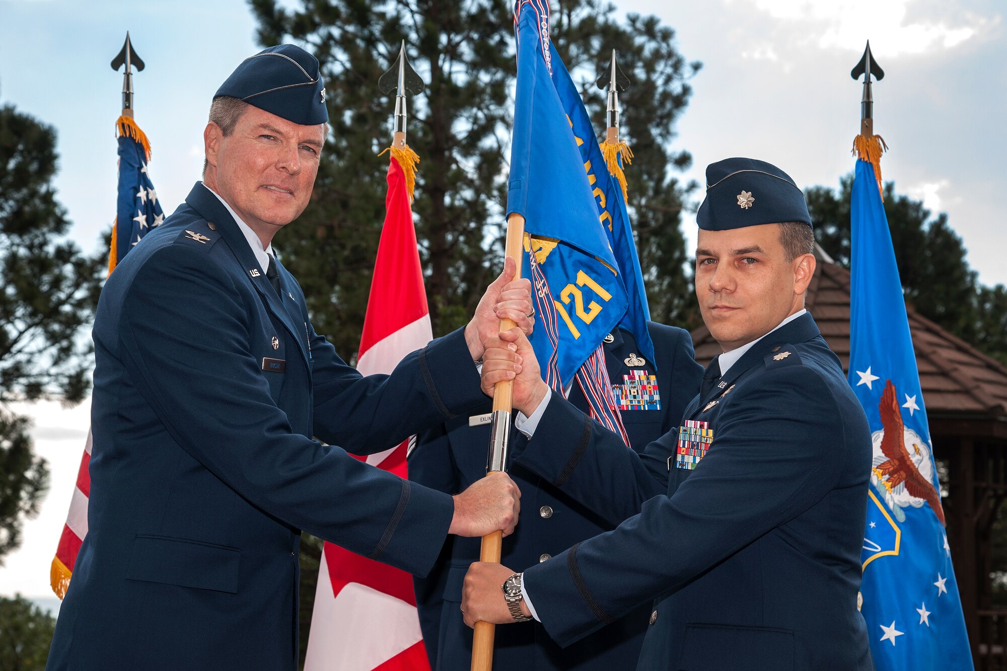 CHEYENNE MOUNTAIN AIR FORCE STATION, Colo. – Col. Travis Harsha (left), 721st Mission Support Group commander, passes the 721st Communications Squadron guidon to Lt. Col. John Yocum, incoming 721st CS commander, during the 721st CS change of command ceremony July 17 here. The 721st Communications Squadron provides integrated tactical warning and attack assessment computers and communications systems support for their customers including NORAD, USSTRATCOM, USNORTHCOM, the secretary of defense, the president and strategic and theater commanders. The ITW/AA mission ensures connectivity of 11 major systems and more than 1,000 data circuits to sensor sites and forward users around the world. (U.S. Air Force photo/Craig Denton)