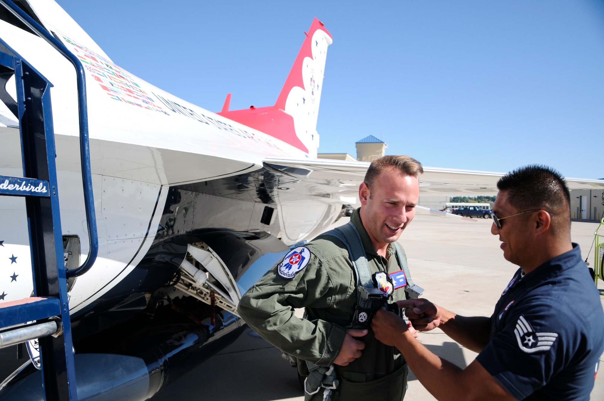 Staff Sgt. Mark Mira, U.S. Air Force Thunderbirds #8 dedicated crew chiefs, helps Cory Sullivan, Root Sports analyst and former Colorado Rockies Outfielder, get suited up for an acrobatic flight in a Thunderbirds F-16 July 21, 2014, at the Wyoming Air National Guard base in Cheyenne, Wyo. During the flight, Maj. Mike Fisher, Thunderbirds #8 advance pilot and narrator, took Sullivan for a ride that included maneuvers including the clover loop, barrel roll, inverted flat pass, vertical rolls and an 8.3 g turn. (U.S. Air Force photo by Airman 1st Class Jason Wiese)