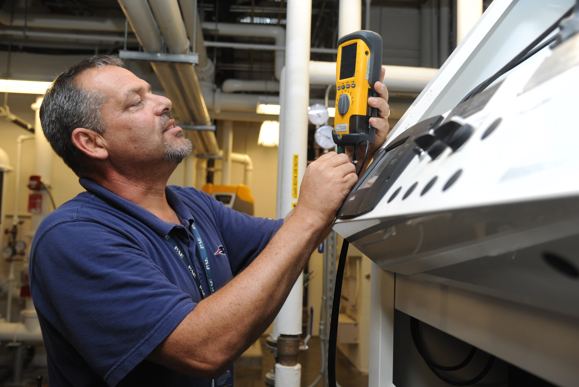 John Grant, Base Operations Support contractor, uses an Ultrasonic Inspection System and Flow Meter that improve system monitoring and calibration inside the 41st Aerial Port building mechanical room July 18, 2014, at Keesler Air Force Base, Miss. This system is utilized as part of the Reliability Centered Maintenance program which evaluates equipment performance piece by piece to determine wear and lifecycle of each item.  The goal of the program is to institute the most cost effective plan for maintaining complex systems and minimize equipment failure or downtime. (U.S. Air Force photo by Kemberly Groue)