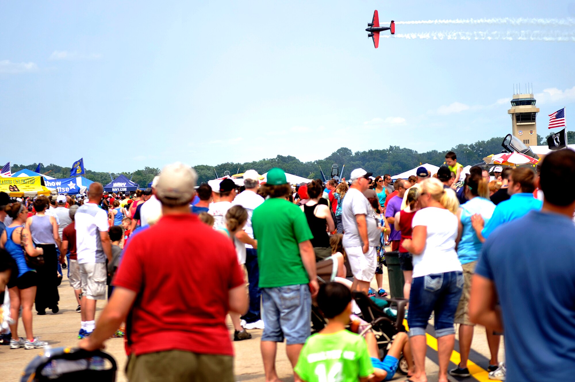 Air show attendees stop and watch Matt Younkin flying his Beech 18 at the 2014 Defenders of Freedom Open House and Air Show July 19 at Offutt Air Force Base, Nebraska.  The Beech 18 Matt Younkin performs in (serial number 4383) was built in 1943 by the Beechcraft Corporation at Wichita, Kansas. Designated an AT-7C, the airplane was bought new by the U.S. Army Air Corps and spent the duration of World War II as a navigation trainer based at Houston’s Ellington Army Air Field.  (U.S. Air Force photo by Jeff W. Gates/Released)