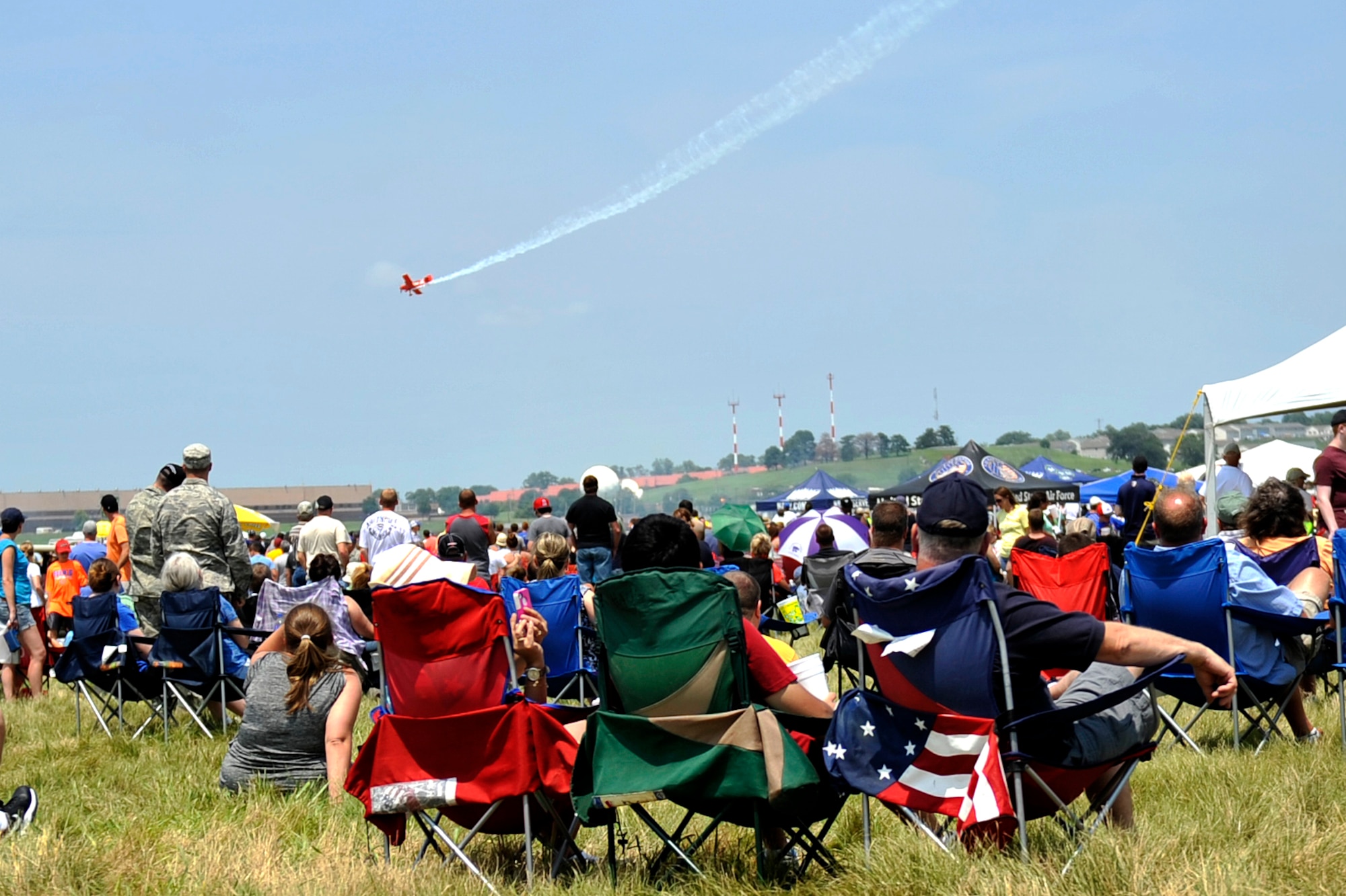 Air show attendees watch Michael Wiskus in the Lucas Oil plane at the 2014 Defenders of Freedom Open House and Air Show July 19 at Offutt Air Force Base, Nebraska.  Michael Wiskus has accumulated more than 24,000 flight hours and has qualified in more than 40 aircraft.  (U.S. Air Force photo by Jeff W. Gates/Released)