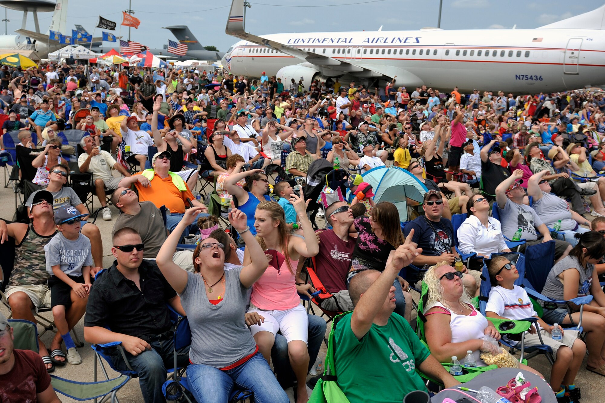Air show attendees admire the aerial demonstrations at the 2014 Defenders of Freedom Open House and Air Show July 19 at Offutt Air Force Base, Nebraska. Patrons enjoyed two days of aerial performances from demonstration teams like the U.S. Navy’s Blue Angels and the U.S. Air Force’s F-22 Raptor.  (U.S. Air Force photo by Jeff W. Gates/Released)