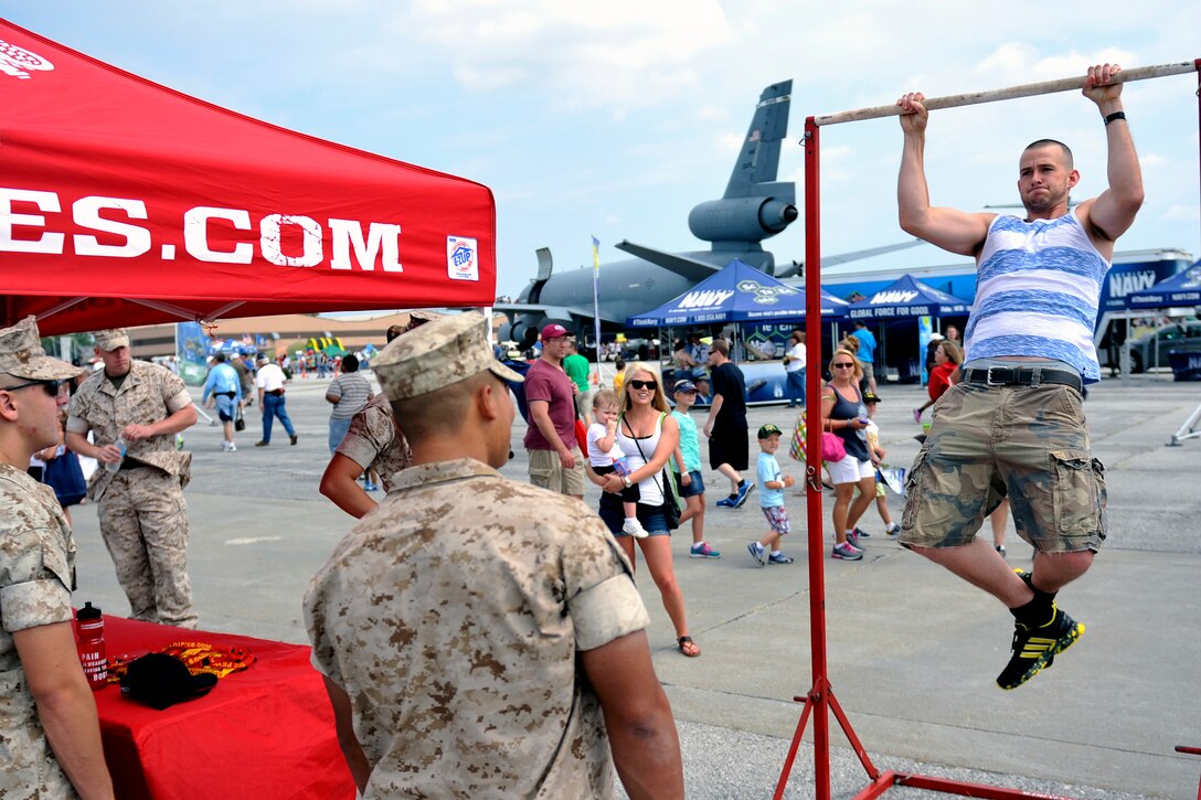 Cory Ridenour of Bellevue, Nebraska, performs pull-ups at the U.S. Marine Corps tent at the 2014 Defenders of Freedom Open House and Air Show July 19 at Offutt Air Force Base, Nebraska. Members from all branches were on hand to explain what their respective branch has to offer through displays and demonstrations.  (U.S. Air Force photo by Jeff W. Gates/Released)
