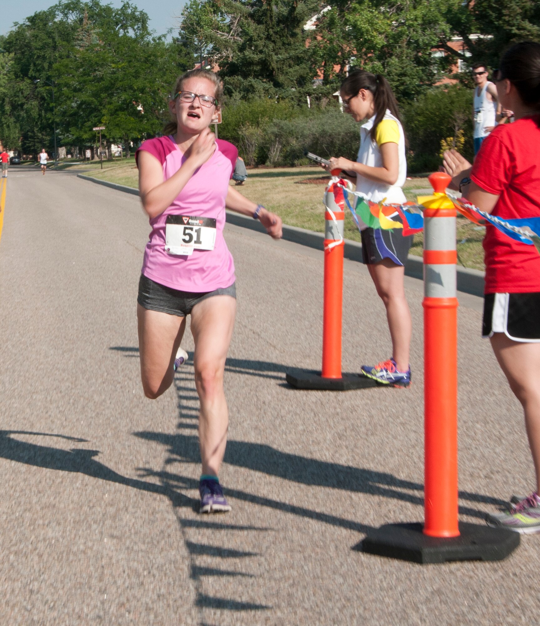 Noelle Savage, Michigan native in Cheyenne for an internship, sprints past the finish line of F.E. Warren Air Force Base’s Buffalo Stampede 5K race July 19, 2014, near the Argonne Parade Field. Savage, a former Michigan Technical University runner, was the first female finisher of the 5K race. (U.S. Air Force photo by Airmen 1st Class Jason Wiese)