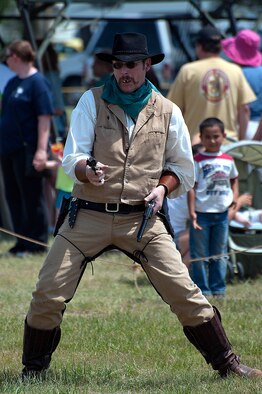 Edward Wilkinson, the 90th CES Operations Flight deputy commander, stands with his guns drawn during the Wyoming Widowmakers’ “High Noon” Gun Fight July 19. Wilkerson performed as one of the villains in the skit, and ended up losing the battle. (U.S. Air Force photo by Airman 1st Class Brandon Valle)