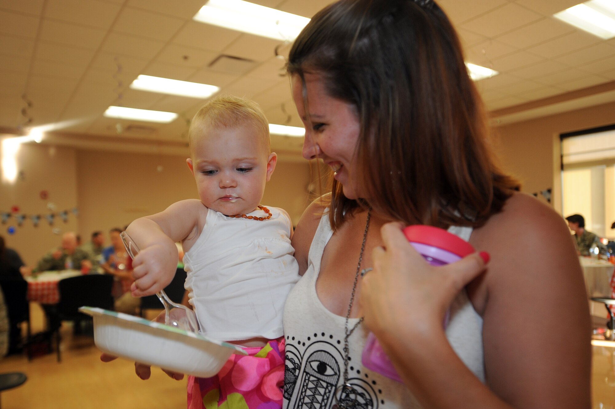 Amber Odom, wife of Staff Sgt. Zachary Odom, 3d Airlift Squadron, and their daughter Scarlette, enjoy some ice cream at a deployed families dinner at the Youth Center July 17, 2014 at Dover Air Force Base, Del. The dinners are held to ensure families know they are not forgotten while their loved ones are deployed. (U.S. Air Force photo/Staff Sgt. Elizabeth Morris)