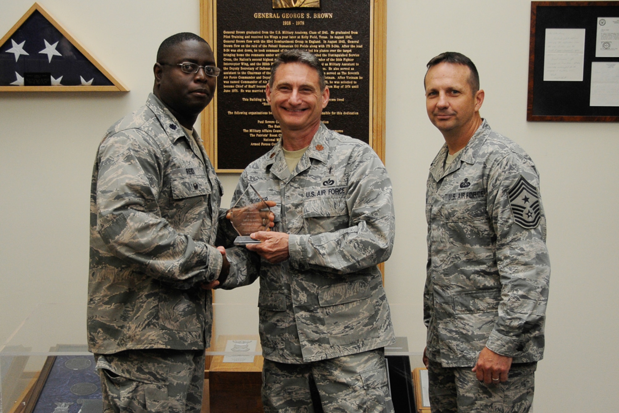 U.S. Air Force Maj. Robert Borger, 66th Air Base Group chaplain, receives a quarterly award from Lt. Col. Romero Reid, former 66th ABG deputy commander, and Chief Master Sgt. Craig Poling, 66th ABG command chief. Borger was one of 12 outstanding Hanscom Airmen who received an award for the second quarter. (U.S. Air Force photo by Linda LaBonte Britt)