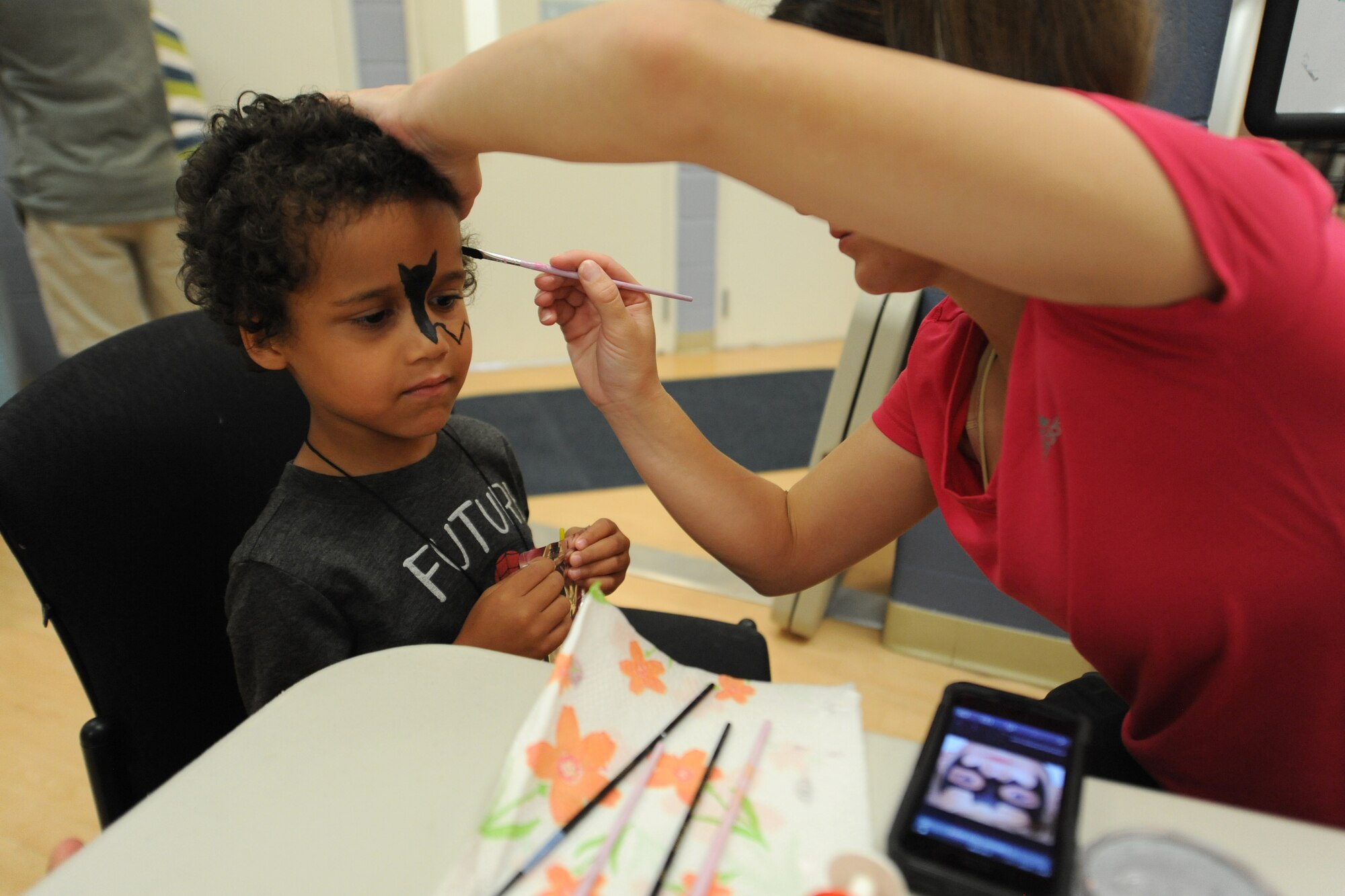 Kaden Harris, son of Technical Sgt. Edward Harris, 736th Aircraft Maintenance Squadron, gets his face painted during a deployed families’ dinner at the Youth Center July 17, 2014 at Dover Air Force Base, Del. The deployed families’ dinner was hosted by the 436th Maintenance Group. (U.S. Air Force photo/Staff Sgt. Elizabeth Morris)