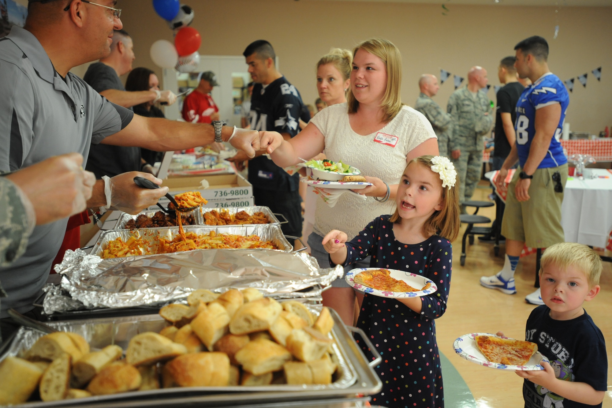Kayla Ruhm, wife of Staff Sgt. Michael Ruhm, 436th Maintenance Squadron, and their children Tory and Logan are served food at the deployed families’ dinner at the Youth Center July 17, 2014 at Dover Air Force Base, Del. The dinner is held quarterly for families with deployed members. (U.S. Air Force photo/Staff Sgt. Elizabeth Morris)
