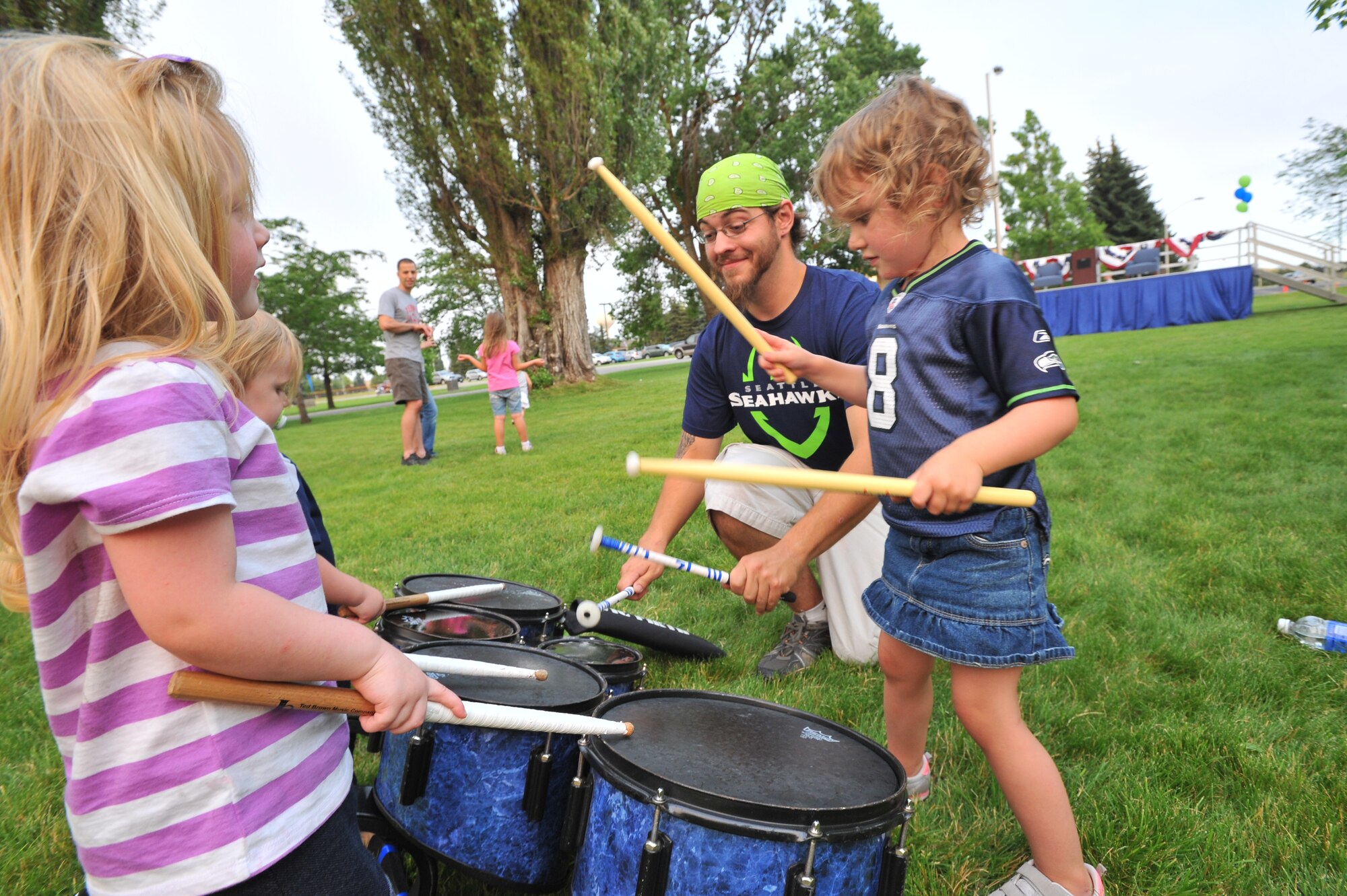Shannon Green, Blue Thunder band tenor drummer, plays instruments with Team Fairchild youth July 18, 2014, at Fairchild Air Force Base, Wash.  Blue Thunder is the band for the Seattle Seahawks and was here as part of their “Heroes of 12” tour.  (U.S. Air Force photo by Staff Sgt. Veronica Montes/Released)