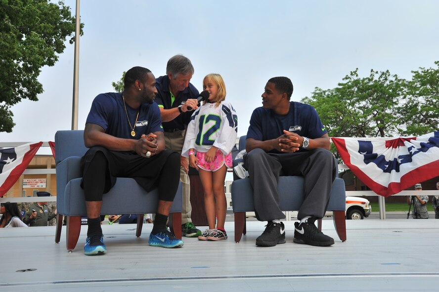 Taylor Gilstrip, a young member of the Fairchild family, asks questions to wide receiver Ricardo Lockette and defensive back DeShawn Shead from the Seattle Seahawks July 18, 2014, at Fairchild Air Force Base, Wash. The team was here as part of their “Heroes of 12” tour and offered a question and answer session for the fans. (U.S. Air Force photo/Staff Sgt. Veronica Montes)