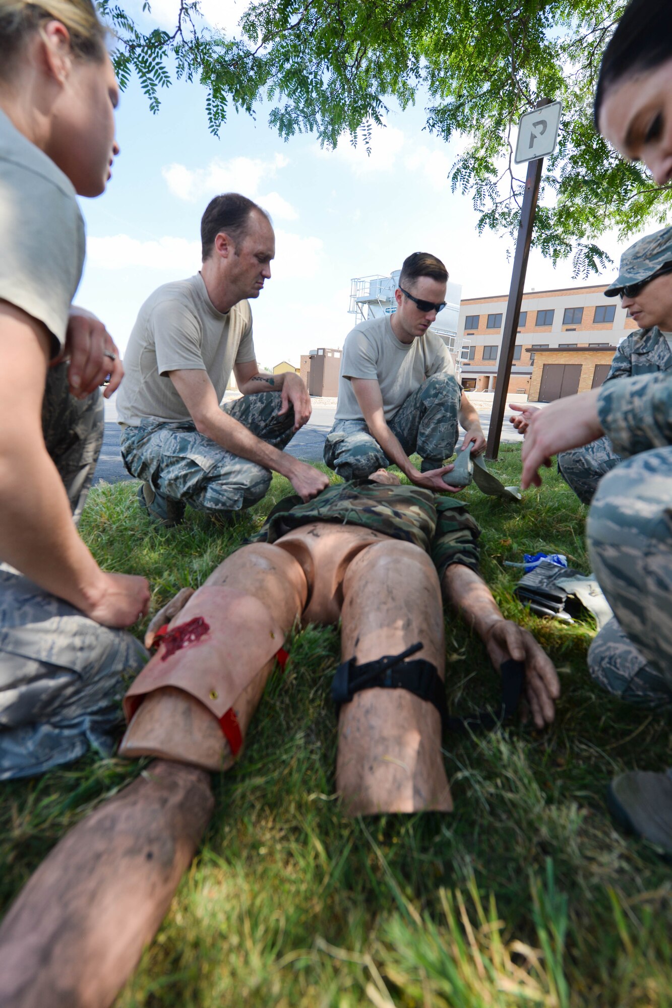 Airmen assigned to the 28th Medical Group practice self-aid and buddy care techniques at Ellsworth Air Force Base, S.D., July 16, 2014 during a training exercise. Participants practiced SABC, building tents, and carrying and loading patients into ambulances to maintain proficiency in patient care and emergency response. (U.S. Air Force photo by Senior Airman Zachary Hada/Released)