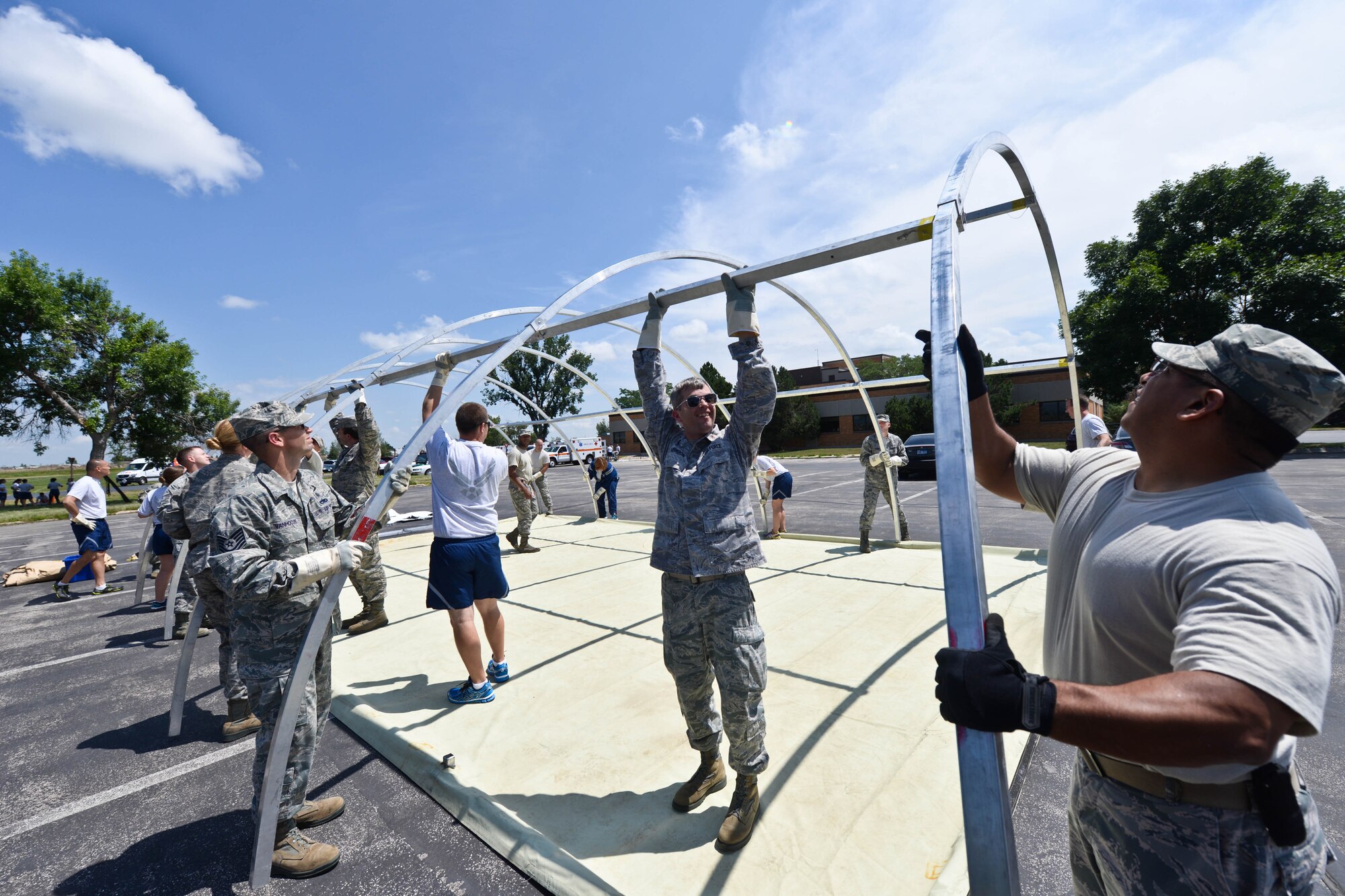 Airmen assigned to the 28th Medical Group practice assembling tents at Ellsworth Air Force Base, S.D., July 16, 2014, during a training exercise.  The exercise provided various scenarios for Airmen to apply and refine their emergency response skills, ensuring they are prepared for possible future incidents. (U.S. Air Force photo by Senior Airman Zachary Hada/Released)