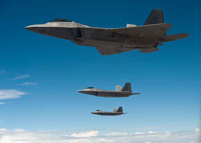 Three U.S. Air Force F-22 Raptors assigned to the 325th Fighter Wing, Tyndall Air Force Base, Fla., fly alongside a KC-135 Stratotanker assigned to the 93rd Air Refueling Squadron, Fairchild AFB, Wash., after completing in-flight refueling during Red Flag 14-3, July 17, 2014, over the Nevada Test and Training Range. Red Flag invites different units, airframes, branches and allied nations the chance to practice various air combat scenarios with one another. These different groups may have to work with one another in future real-world operations. (U.S. Air Force photo by Airman 1st Class Thomas Spangler)