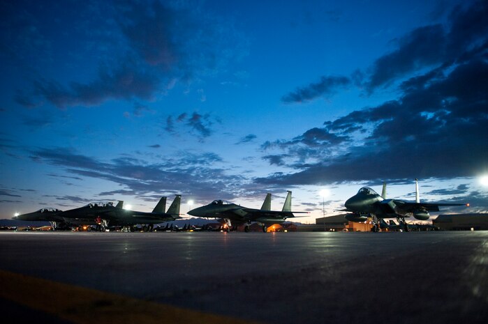Four U.S. Air Force F-15 Eagles line the flightline for final pre-flight checks before night operations begin during Red Flag 14-3, July 16, 2014, at Nellis Air Force Base, Nev. Red Flag exercises provide participating units with intense realistic air-to-air combat training in an operationally limited environment. The low visibility that comes with night operations adds to the stress level of air and ground crews, further preparing them for future missions. (U.S. Air Force photo by Airman 1st Class Thomas Spangler)