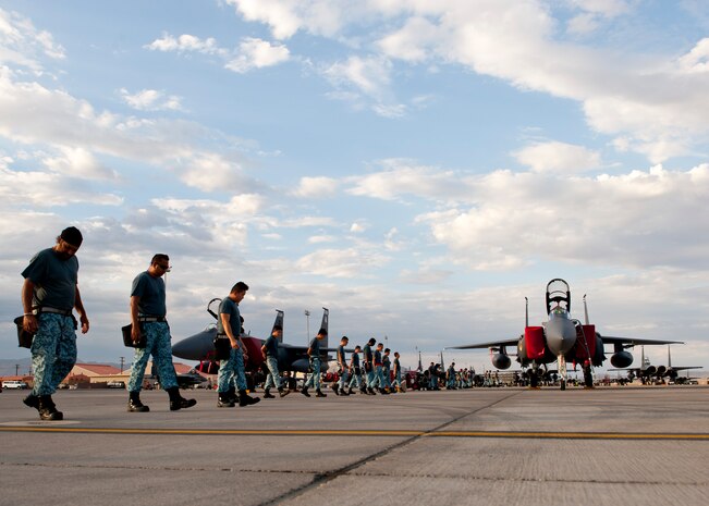 Singapore air force aircraft maintainers walk down the flightline looking for foreign object debris before night operations begin during Red Flag 14-3, July 16, 2014, at Nellis Air Force Base, Nev. Red Flag exercises involve air and ground crews from the U.S. and its allies. It gives participants the chance to hone their combat skills in as realistic an environment as possible. (U.S. Air Force photo by Airman 1st Class Thomas Spangler)