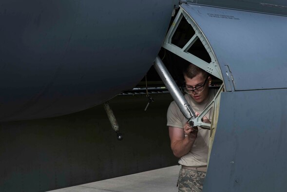 Airman 1st Class James Rutt, 5th Aircraft Maintenance Squadron weapons load crew member, adjusts the hinge on a B52-H Stratofortress on Minot Air Force Base, N.D., during a load crew competition July 11, 2014. The crew with the fastest completion time is named the load crew of the quarter. (U.S. Air Force photos/Airman 1st Class Lauren Pitts)  