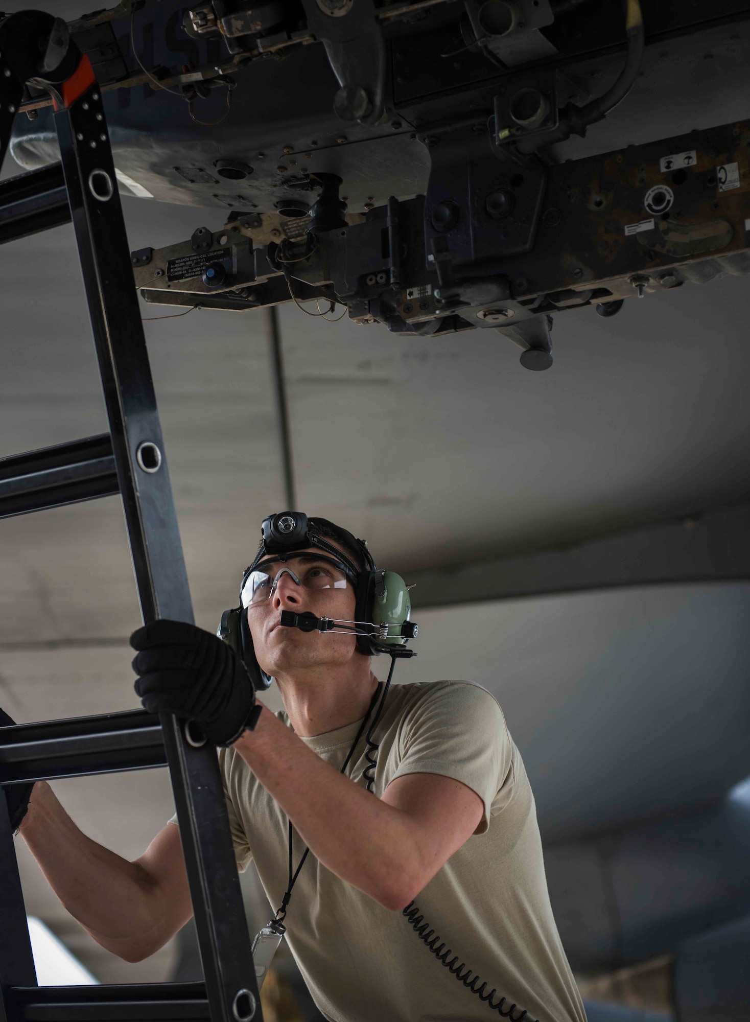 Senior Airman Matthew Brimmer, 5th Aircraft Maintenance Squadron weapons load crew member, climbs a latter to inspect a bomb rack during a bomb-loading crew competition on Minot Air Force Base, N.D., July 11, 2014. The competitions are held between loading crews to see who can complete the task better and faster, naming the winner the Load Crew of the Quarter. (U.S. Air Force photos/Airman 1st Class Lauren Pitts) 