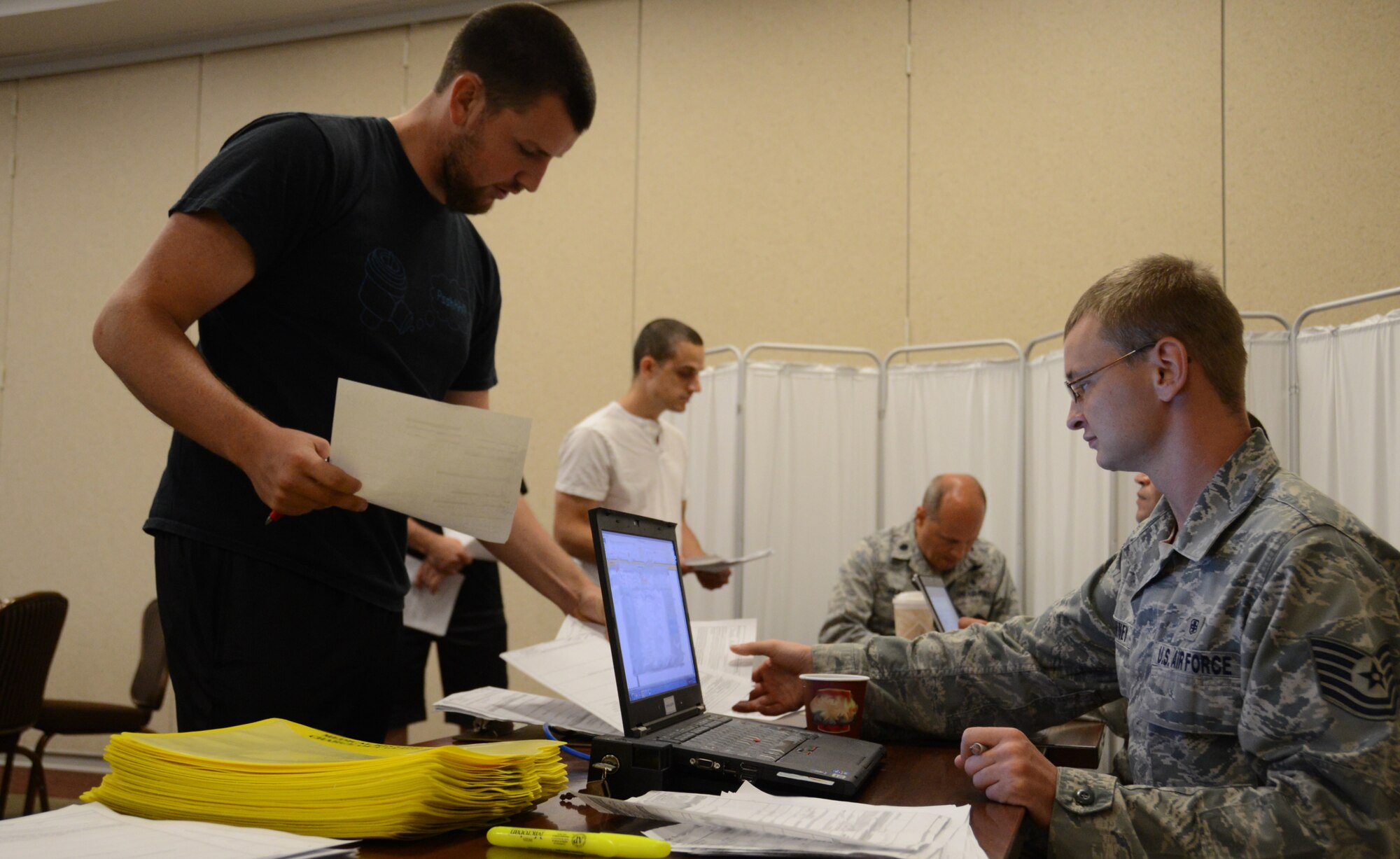 An Individual Ready Reserve Airman submits medical paperwork during an IRR Muster July 19, 2014 at the Niagara Falls Air Reserve Station, N.Y. The Muster was held at the Community Activities Center here, and the Airmen met with different sections for screening. This screening was to ensure all of their paperwork was correct and included meeting with medical, Veteran Affairs, personnel and 914th Airlift Wing recruiters. (U.S. Air Force photo illustration by Tech. Sgt. Andrew Caya)