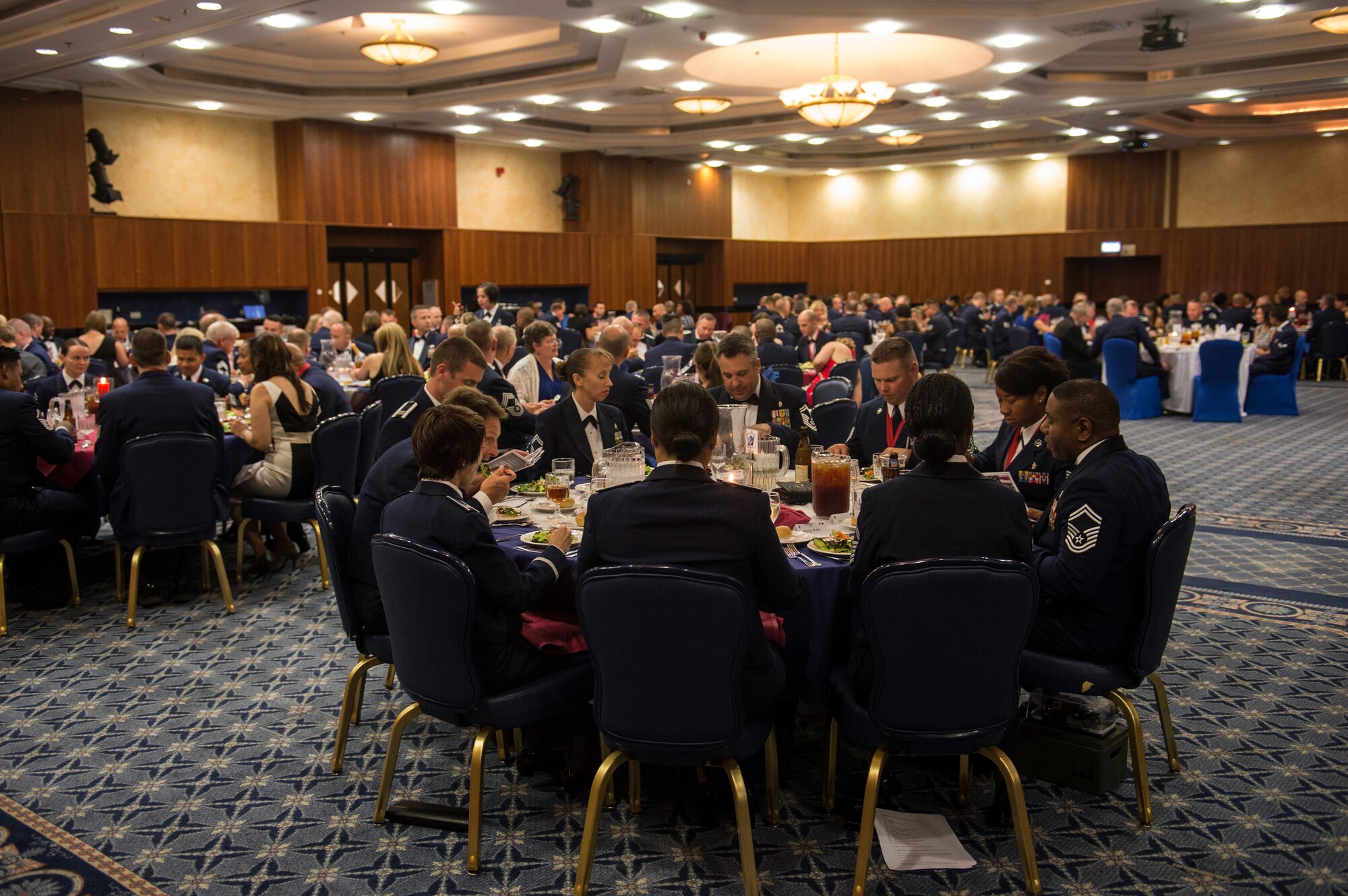 Airmen eat dinner during the Senior NCO Induction Ceremony July 18, 2014, at Spangdahlem Air Base, Germany. More than 60 technical sergeants and one master sergeant received recognition for their induction to Senior NCO tier. (U.S. Air Force photo by Senior Airman Rusty Frank/Released)