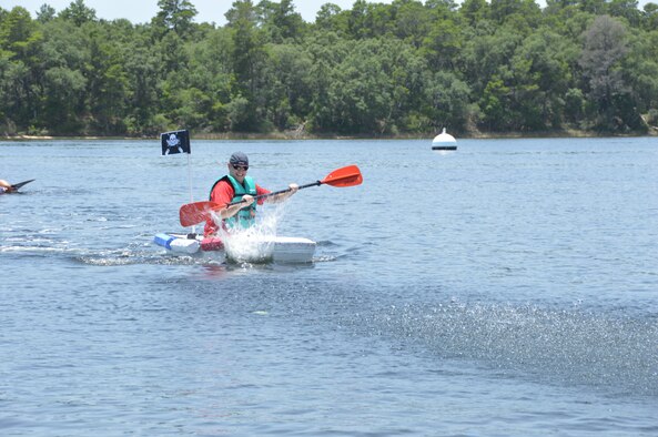 Staff Sgt. James Clark of Air Forces Northern's Manpower, Personnel and Services Directorate, paddles the directorate's entry to victory during a cardboard boat race at AFNORTH Family Day June 27 at Bonita Bay. (Photo by Mary McHale) 


