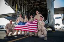 Aircrew from the 737th Expeditionary Airlift Squadron pose behind a C-130H Hercules after a day of flying July 20, 2014 at an undisclosed location in Southwest Asia. The crew just finished a mission transporting personnel and equipment to two locations in area of responsibility. The entire crew deployed here together from the 910th Airlift Wing, Youngstown Air Reserve Station, Ohio in support of Operation Enduring Freedom. (U.S. Air Force photo by Staff Sgt. Jeremy Bowcock)