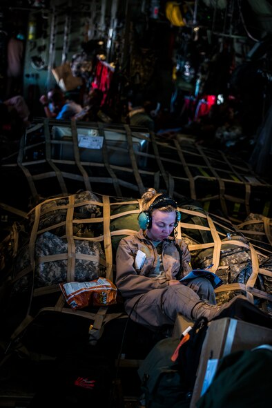 U.S. Air Force Staff Sgt. Kacie Adsit, 737th Expeditionary Airlift Squadron C-130H loadmaster, relaxes while completing a crossword puzzle during flight July 20, 2014 at an undisclosed location in Southwest Asia. Loadmasters ensure all cargo and personnel to be transported on a plane are secured and placed to ensure the plane can safely fly. Adsit deployed here from the 910th Airlift Wing, Youngstown Air Reserve Station, Ohio in support of Operation Enduring Freedom. (U.S. Air Force photo by Staff Sgt. Jeremy Bowcock)