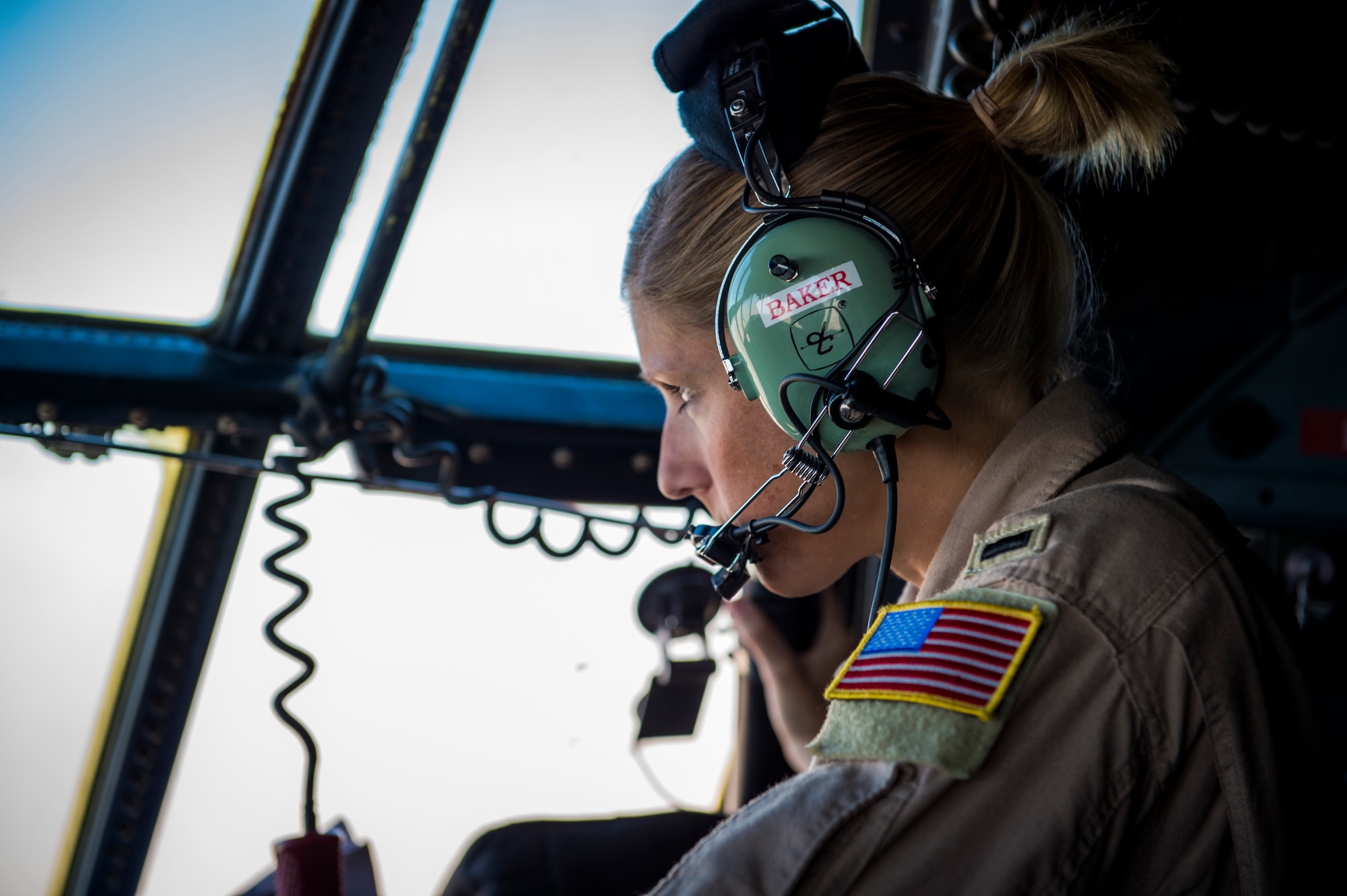 U.S. Air Force 1st Lt. Shannon Baker, 737th Expeditionary Airlift Squadron C-130H navigator, looks out the window of a C-130H Hercules during flight July 20, 2014 at an undisclosed location in Southwest Asia. Baker deployed here from the 910th Airlift Wing, Youngstown Air Reserve Station, Ohio in support of Operation Enduring Freedom. (U.S. Air Force photo by Staff Sgt. Jeremy Bowcock)