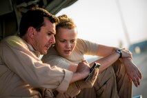 U.S. Air Force Master Sgt. Scott Francesangeli and Staff Sgt. Kacie Adsit, 737th Expeditionary Airlift Squadron C-130H loadmasters, plan for the cargo and personnel they are about to load July 20, 2014 at an undisclosed location in Southwest Asia. Loadmasters ensure all cargo and personnel to be transported on a plane are secured and properly placed to ensure the plane can safely fly. Both Airmen deployed here from the 910th Airlift Wing, Youngstown Air Reserve Station, Ohio in support of Operation Enduring Freedom. (U.S. Air Force photo by Staff Sgt. Jeremy Bowcock)