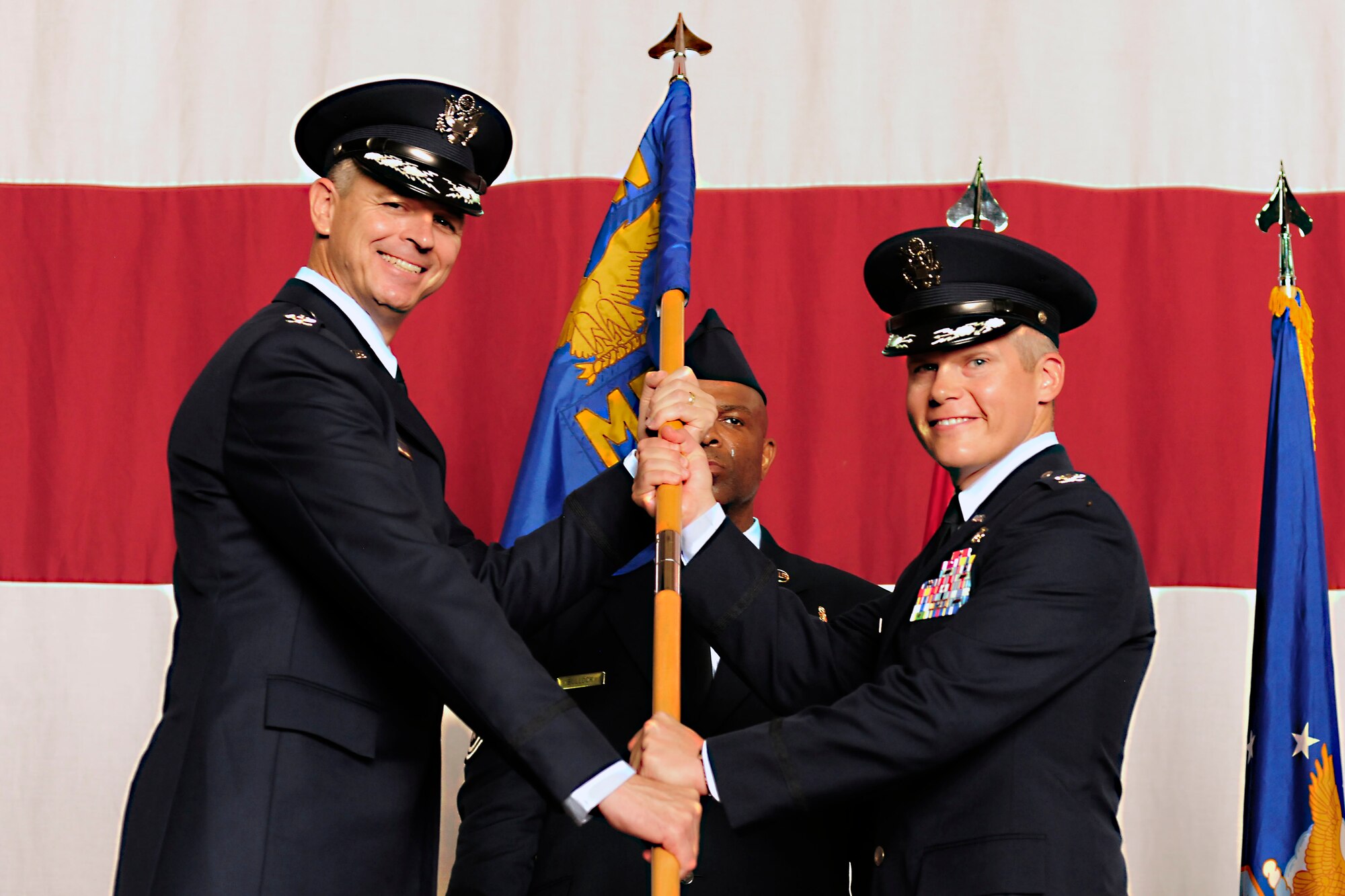 Col. Craig Wills, 39th Air Base Wing commander, passes the guidon to Col. Andrew Meadows, 39th Medical Group commander, during the 39th MSG change of command ceremony July 22, 2014, Incirlik Air Base, Turkey. The ceremony signified the transition of command from Col. Jerome Wizda to Meadows. (U.S. Air Force photo by Staff Sgt. Eboni Reams)