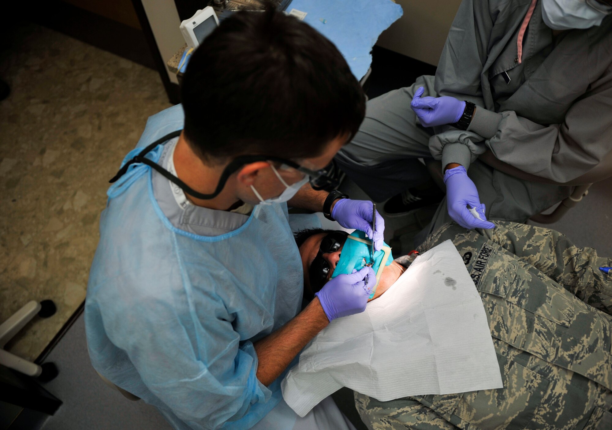 Capt. Jon Federspiel, 51st Dental Squadron general dentist, performs a root canal procedure on a patient on Osan Air Base, Republic of Korea, July 16, 2014. A root canal procedure is a treat the pulp of a tooth that is inflamed, infected or dead. (U.S. Air Force photo by Senior Airman David Owsianka)