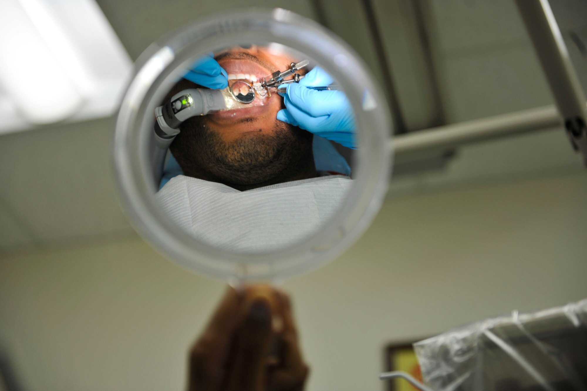 Staff Sgt. Devin Elliot, 51st Force Support Squadron, watches the progress of his dental appointment on Osan Air Base, Republic of Korea, July 16, 2014. The dentist performed a tooth-color filling restoration procedure. (U.S. Air Force photo by Senior Airman David Owsianka)