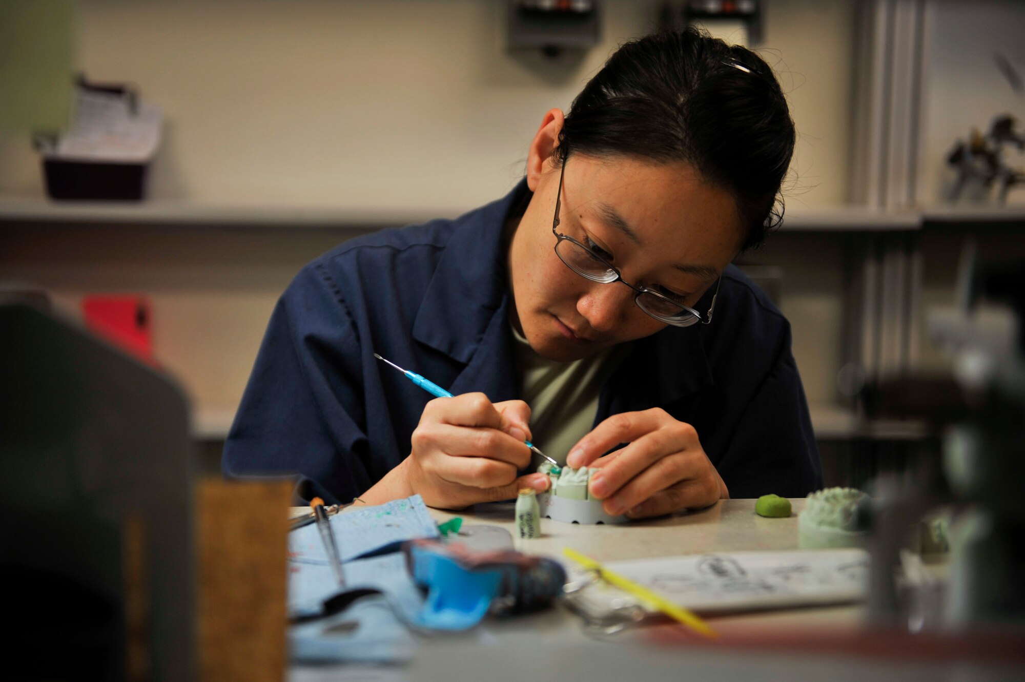 Staff Sgt. Janine Sung, 51st Dental Squadron laboratory technician, uses an instrument to evenly place wax around a stone mold tooth to provide a crown for a patient’s tooth on Osan Air Base, Republic of Korea, July 16, 2014. Once completed, a dentist will trim away the unfavorable area on the tooth of a patient to place the new crown on top of it. (U.S. Air Force photo by Senior Airman David Owsianka)
