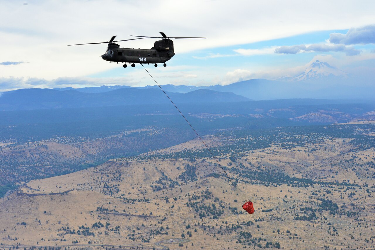 An Oregon Army National Guard CH-47 Chinook helicopter returns to the Madras Airport after successfully dumping water on a target area in the Logging Unit fire west of Madras, Ore., July 20, 2014. Two CH-47 Chinook helicopters and two HH-60M Black Hawk helicopters of the Oregon Army National Guard arrived at the Madras Airport the day before to assist local authorities in suppressing the wildfire west of Madras. U.S. Army photo by Staff Sgt. Jason Van Mourik
