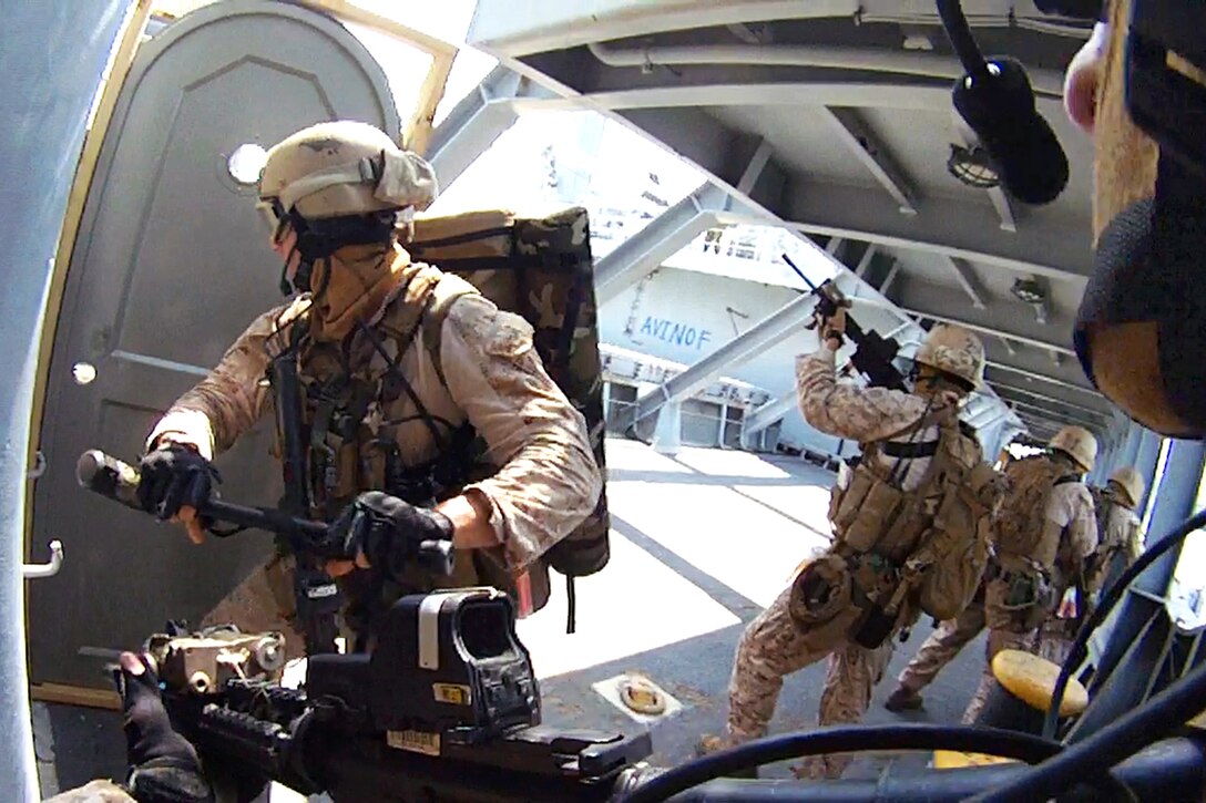 Marines and sailors breach a door with a sledge hammer during a visit, board, search and seizure exercise as part of realistic urban training near Joint Base Langley-Eustis, Va., July 13, 2014.