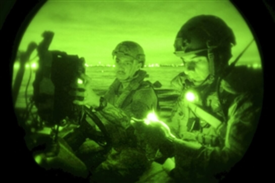 As seen through a night-vision device, U.S. sailors navigate a rubber craft during a training exercise off the coast of San Diego during Rim of the Pacific, an exercise in the Pacific Ocean, July 19, 2014. The sailors are assigned to Explosive Ordnance Disposal Mobile Unit 1. Twenty-two nations, 49 ships, six submarines, more than 200 aircraft and 25,000 personnel are participating in the exercise in and around the Hawaiian Islands and Southern California. 