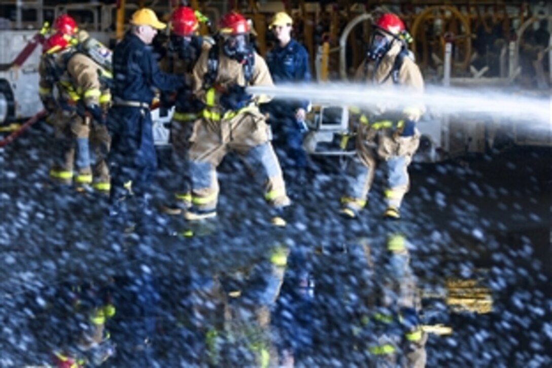 U.S. sailors practice hose handling during a general quarters drill in the hangar bay of the USS Harry S. Truman in the Atlantic Ocean, July 18, 2014. The drills prepare sailors for readiness in the event of actual casualties.