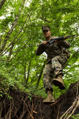Lance Cpl. Juan Gonzales, an expeditionary airfield technician with Headquarters and Headquarters Squadron, augmented to Combat Logistics Company 36, hurdles an obstacle while patrolling during land navigation training as a part of Exercise Dragon Fire 2014 at Combined Arms Training Center Camp Fuji, Japan, July 13. Dragon Fire is CLC-36’s annual Battle Skills Training exercise that focuses on improving the individual and collective combat skills of CLC-36 service members with an emphasis on weapons familiarization training. 