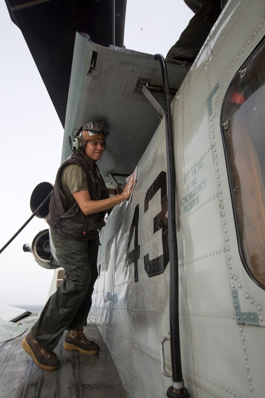 U.S. 5TH FLEET AREA OF RESPONSIBILITY (July 16, 2014) U.S. Marine Corps Lance Cpl. Anthony Penaflor, Marine Medium Tiltrotor Squadron (VMM) 263 (Reinforced), 22nd Marine Expeditionary Unit (MEU), CH-53E Super Stallion crew chief and native of Chino Hills, Calif., washes a Super Stallion aboard the amphibious transport dock ship USS Mesa Verde (LPD 19). The 22nd MEU is deployed with the Bataan Amphibious Ready Group as a theater reserve and crisis response force throughout U.S. Central Command and the U.S. 5th Fleet area of responsibility. (U.S. Marine Corps photo by Cpl. Manuel A. Estrada/Released)