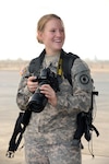 Army Spc. Michelle Lawrence, 35th Military Police Company combat medic currently serving as a unit public affairs representative for the 1st Battalion 161st Field Artillery, Kansas Army National Guard, adjusts her camera settings at Camp Lemonnier, June 30, 2011. Lawrence is a combat medic, but was designated as a unit public affairs representative for the 1-161 FA BN shortly after deploying to Africa. She calls Dighton, Kan., home.