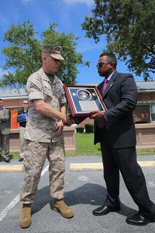 Major Jason Wintermute, left, receives an official accreditation plaque from Maceo Frank during a ceremony at Marine Corps Air Station Cherry Point July 17, 2014. The Provost Marshal's Office earned the federal accreditation after a 15-month process. Wintermute is the provost marshal for the air station and Frank is the Law Enforcement Academy East Director with Headquarters Marine Corps' Plans, Policies and Operations Law Enforcement and Corrections Branch.


