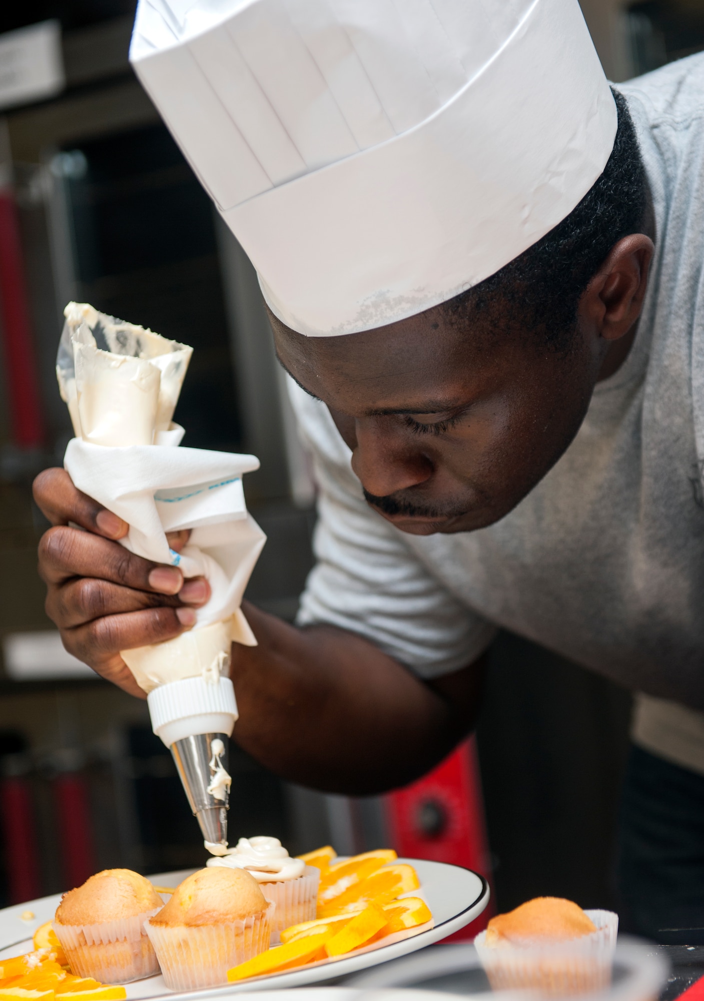 Staff Sgt. Phillip Burns II decorates cupcakes during Cupcake Wars 3 July 23, 2013, on Moody Air Force Base, Ga. Burns and his teammate Senior Airman Vincent MiGliorino, were the first males to compete in the competition. Burns is a 23d Civil Engineer Squadron fire inspector. (U.S. Air Force photo/Senior Airman Jarrod Grammel)