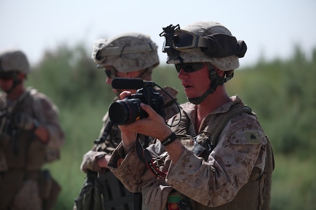 U.S. Marine Corps Cpl. Charles Mabry, a combat cameraman with the 2nd Marine Division Combat Camera, records video while working with Marines with the 2nd Light Armored Reconnaissance Battalion on patrol near Combat Outpost Castle, Helmand province, Afghanistan, May 30, 2011. The Marines patrolled the area to show continued presence and to provide security for the area. (U.S. Marine Corps photo by Chief Warrant Officer 2nd Class Clinton W. Runyon/Released)