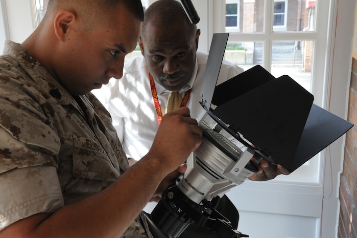 U.S. Marine Corps Sgt. Omar Elorza, left, a videographer assigned to Headquarters Marine Corps (HQMC) Combat Camera, and Rick Robinson, the head of the unit's video section, make adjustments on a studio light in preparation for an interview with retired Lt. Gen. John F. Sattler at Marine Barracks Washington's Center House in Washington, D.C., May 18, 2011. The interview was for a going-away video HQMC Combat Camera produced for Sgt. Maj. of the Marine Corps Carlton W. Kent. (U.S. Marine Corps photo by Lance Cpl. Cody A. Fodale/Released)