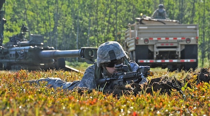 A Soldier assigned to the 1st Battalion, 119th Field Artillery Regiment, Michigan National Guard, prepares for contact from opposing forces in his hasty fighting position during the Field Artillery Defense situation training exercise lane during the eXportable Combat Training Capability exercise on Camp Grayling Joint Maneuver Training Center, Mich., July 17, 2014. (U.S. Army photo by Sgt. Jeremy Miller/Released)