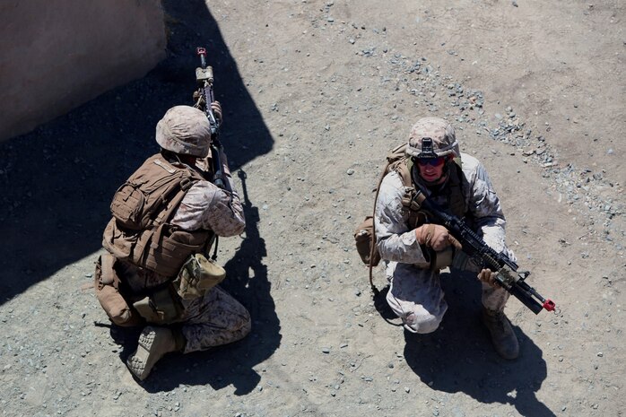 Lance Cpl. Jared Harper, 19, from Ranch Cucamonga, Calif., an assaultman with Company E, 2nd Battalion, 4th Marine Regiment, and Cpl. Nicholas Hamilton, 22, from Lakeside City, Texas, a squad leader with the company provides security during a training exercise aboard Marine Corps Base Camp Pendleton, Calif., July 16, 2014. The training was part of a battalion field exercise where Marines continued to improve their urban combat skills with the assistance of the Infantry Immersion Trainer. The IIT provides a training facility for practical application of tactical skills and decision making in an immersive, scenario-based training environment.