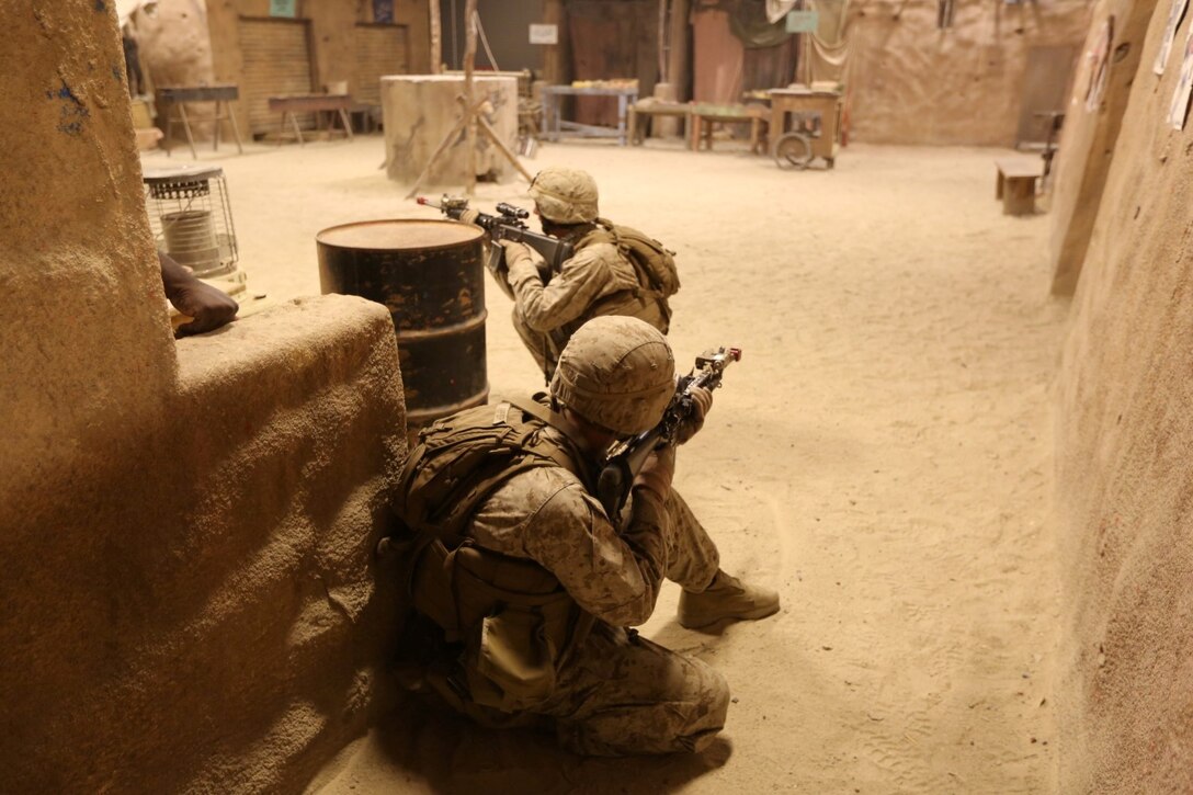 Marines with Company E, 2nd Battalion, 4th Marine Regiment, provide security during a training exercise aboard Marine Corps Base Camp Pendleton, Calif., July 16, 2014. The training was part of a battalion field exercise where Marines continued to improve their urban combat skills with the assistance of the Infantry Immersion Trainer. The IIT provides a training facility for practical application of tactical skills and decision making in an immersive, scenario-based training environment.