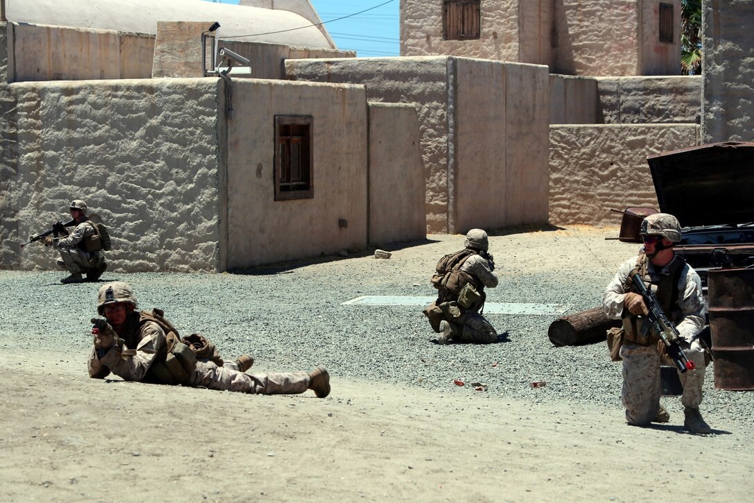 Marines with Company E, 2nd Battalion, 4th Marine Regiment, provide security during a training exercise aboard Marine Corps Base Camp Pendleton, Calif., July 16, 2014. The training was part of a battalion field exercise where Marines continued to improve their urban combat skills with the assistance of the Infantry Immersion Trainer. The IIT provides a training facility for practical application of tactical skills and decision making in an immersive, scenario-based training environment.
